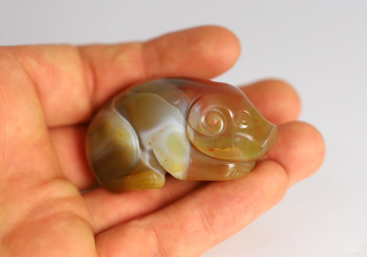 A Chinese banded agate figure of a recumbent pig, 18th/19th century, 5.4cm long, wood stand
